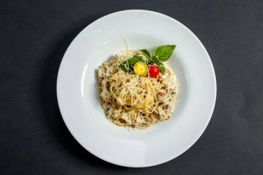 Mantarlı ve peynirli makarna, krema soslu bıldırcın yumurtası ve domates, izole edilmiş.