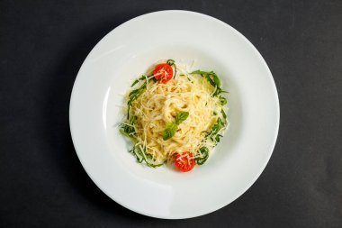 Lezzetli iştah açıcı klasik İtalyan spagettisi domates soslu makarna, peynirli parmesan ve siyah tabakta fesleğen.