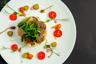 Beyaz tabakta etli ve malzemeli salata.