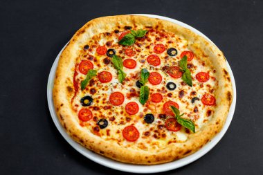 Peynirli ve fesleğenli sıcak İtalyan pizzası, izole edilmiş.