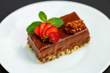 Fındık ve böğürtlenli bir dilim çikolatalı pasta.