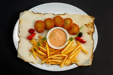 Kızarmış patates ve ketçaplı lezzetli nuggetlar.