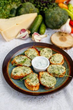 Süslü bir masada çiğ sebzeli sarımsaklı ekmek ve sos.