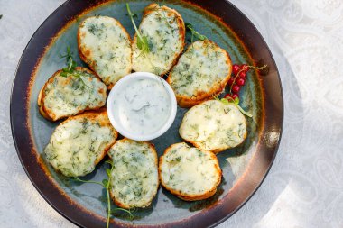 Süslü bir masada çiğ sebzeli sarımsaklı ekmek ve sos.