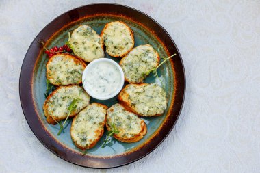 Süslü bir masada çiğ sebzeli sarımsaklı ekmek ve sos.