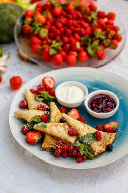 Taze böğürtlenli krep, reçel ve sos süslemeli masaya.
