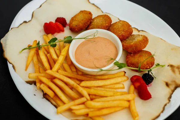 Kızarmış patates ve ketçaplı lezzetli nuggetlar.