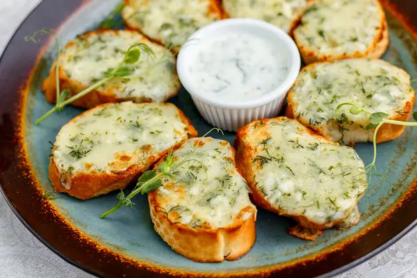 Süslü bir masada çiğ sebzeli sarımsaklı ekmek ve sos.