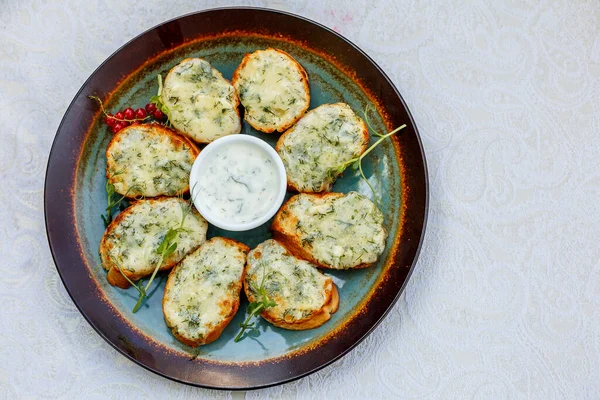 Süslü bir masada çiğ sebzeli sarımsaklı ekmek ve sos.