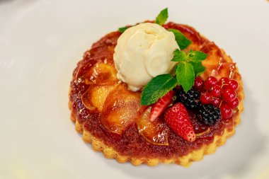 Tatlı, bir kepçe dondurma ve beyaz bir masada beyaz bir tabakta meyveli Belçika waffle 'ı.