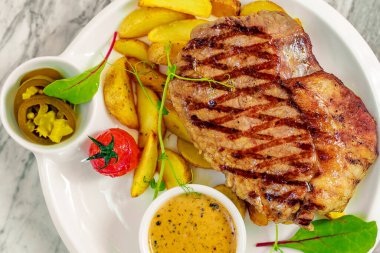 Sebzeli biftek, biber sosu ve biber.