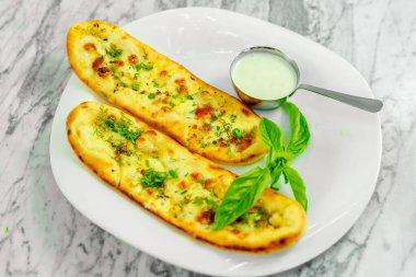 Peynirli sarımsaklı ekmek ve soslu otlar. Güzel atış.