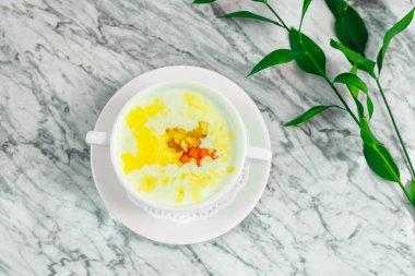 Kahvaltı, ballı sütlü pirinç lapası ve beyaz tabakta kurutulmuş meyve, güzel servis.