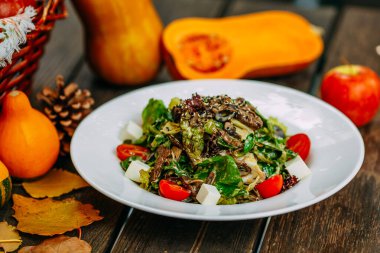 Balkabaklarıyla sonbahar sofrası. Şükran Günü yemeği. Domatesli ve peynirli vejetaryen salatası. Sağlıklı yemek.