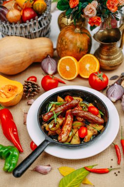 Balkabaklarıyla sonbahar sofrası. Şükran Günü yemeği. Tavada kızarmış patatesli sosis.