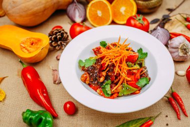 Balkabaklarıyla sonbahar sofrası. Şükran Günü yemeği. Sıcak salata, patlıcan ve hamurda kızartılmış tavuk fileto, ahşap mantar, acı biber, domates.