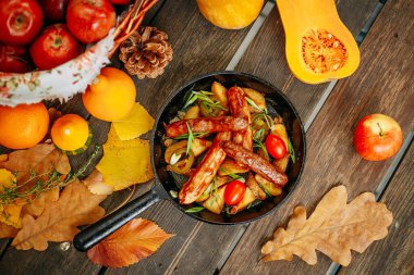 Balkabaklarıyla sonbahar sofrası. Şükran Günü yemeği. Tavada kızarmış patatesli sosis.