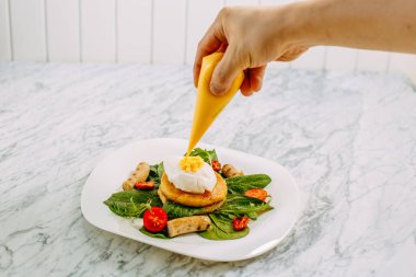 Haşlanmış yumurtalı börek ve mermer masada tavuk sosisi.