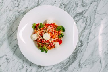 İtalyan spagettisi, mermer bir masada peynir ve otlarla.