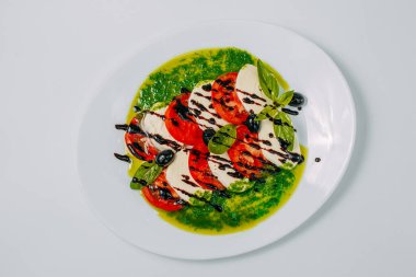 Domatesli ve zeytinli yumuşak mozzarella peyniri beyaz arka planda izole edilmiş sağlıklı yiyecekler.