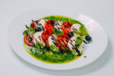 Domatesli ve zeytinli yumuşak mozzarella peyniri beyaz arka planda izole edilmiş sağlıklı yiyecekler.