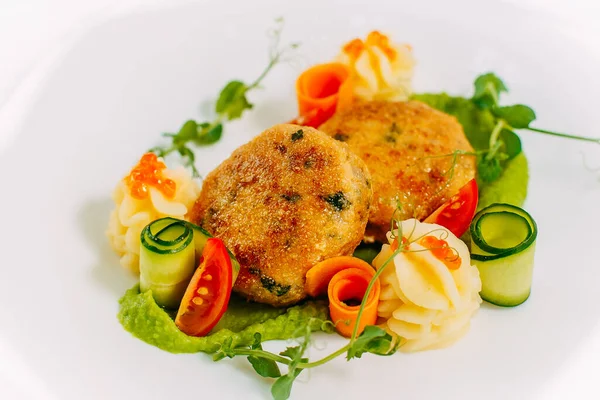 Havyarlı balık köftesi ve mermer bir masada sebze.