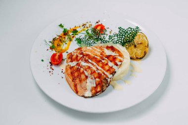 Izgara tavuk göğsü ve beyaz arka planda patates püresi.