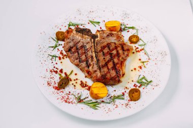 Beyaz arka planda baharatlı ızgara biftek.