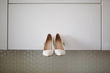 Gelin düğün ayakkabıları ile yüksek topuklar ve koyun kılığına üzerinde gümüş pırlanta küpe