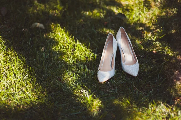 Gelin düğün ayakkabıları ile yüksek topuklar ve koyun kılığına üzerinde gümüş pırlanta küpe