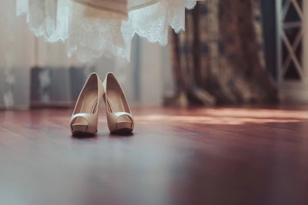 Sapatos de casamento da noiva com saltos altos e brincos brilhantes de prata na roupa de ovelha — Fotografia de Stock