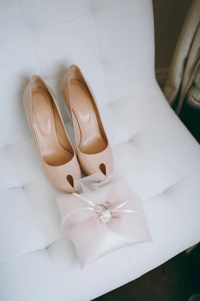 Наречена весільне взуття на високих підборах і срібні блискучі сережки на овечому одязі — стокове фото