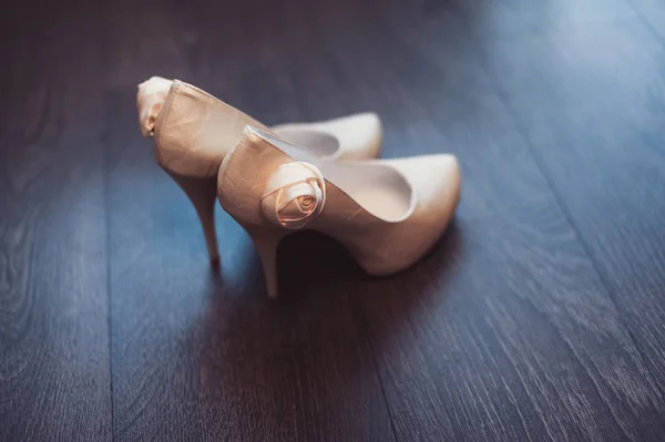 Brud bröllop skor med höga klackar och lysande silverörhängen på fårakläder — Stockfoto