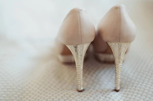 Zapatos de novia de boda con tacones altos y pendientes brillantes de plata en la ropa de oveja — Foto de Stock