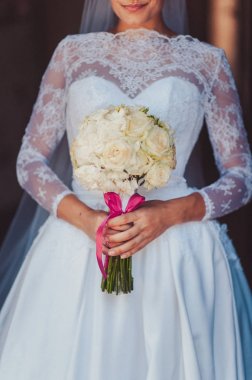 Gelin düğün töreninde büyük bir buket tutuyor.