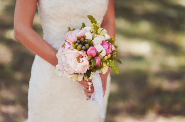 Gelin düğün töreninde büyük bir buket tutuyor.