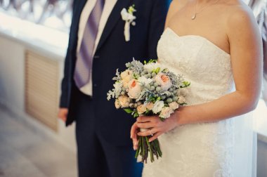 Gelin düğün töreninde büyük bir buket tutuyor.