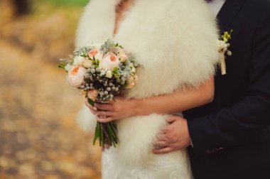 Gelin düğün töreninde büyük bir buket tutuyor.