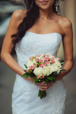 Gelin düğün töreninde büyük bir buket tutuyor.