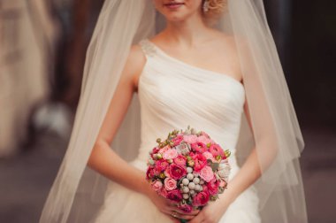 Gelin düğün töreninde büyük bir buket tutuyor.