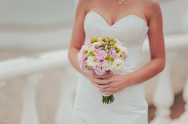 Gelin düğün töreninde büyük bir buket tutuyor.