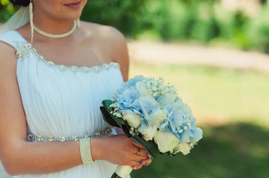 Gelin düğün töreninde büyük bir buket tutuyor.