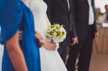 Gelin düğün töreninde büyük bir buket tutuyor.