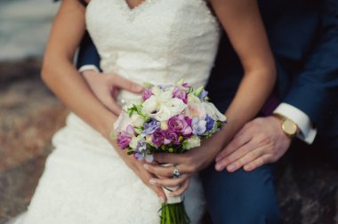 Gelin düğün töreninde büyük bir buket tutuyor.