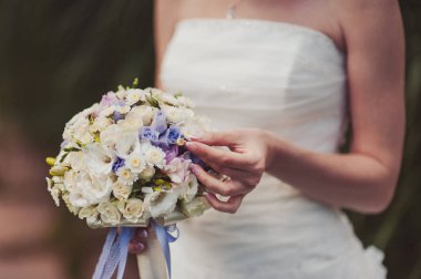 Gelin düğün töreninde büyük bir buket tutuyor.