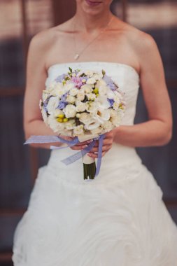 Gelin düğün töreninde büyük bir buket tutuyor.