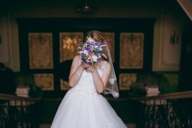 Gelin düğün töreninde büyük bir buket tutuyor.