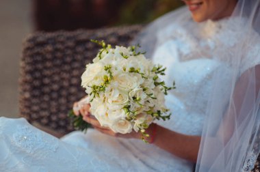 Gelin düğün töreninde büyük bir buket tutuyor.