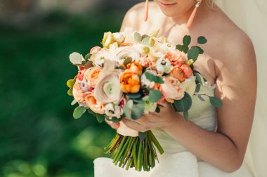 Gelin düğün töreninde büyük bir buket tutuyor.