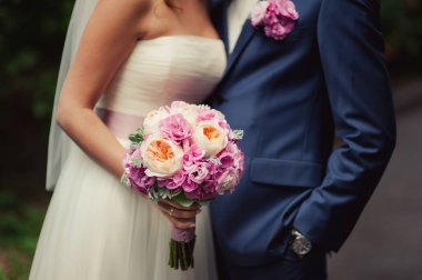 Gelin düğün töreninde büyük bir buket tutuyor.